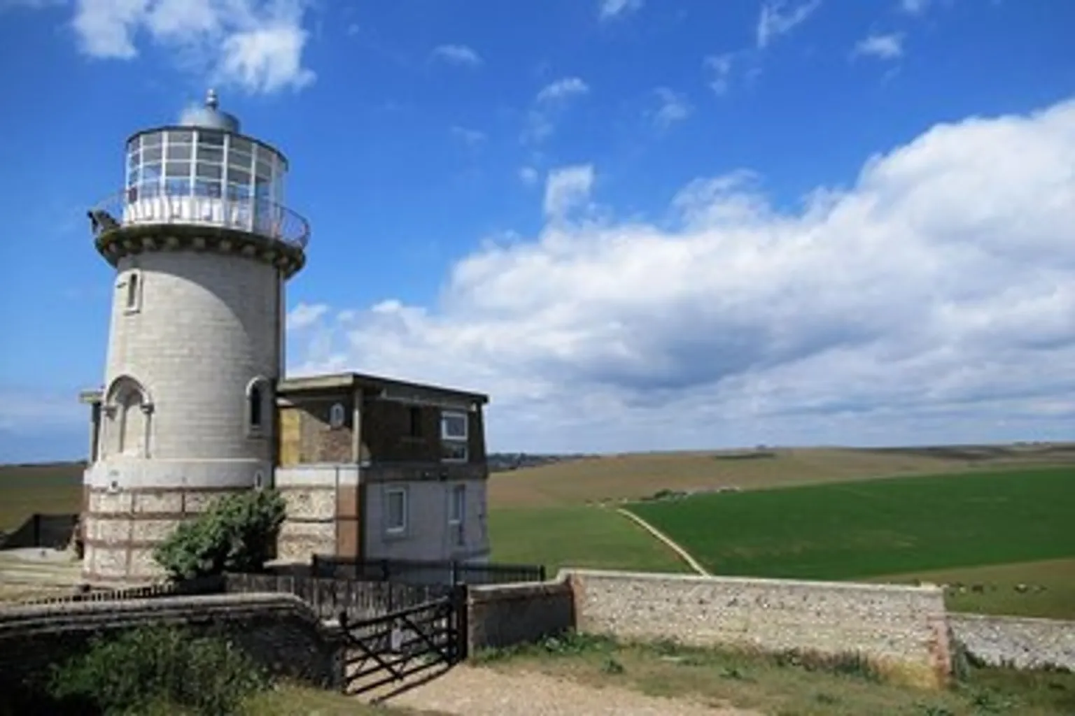 Small photo of the Belle Tout lighthouse in green fields, stretched 4× and blurry